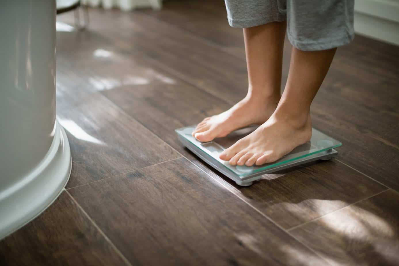 Boy checking his weight on weight scale